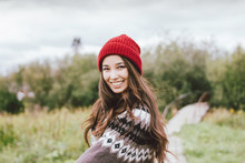 Beautiful Carefree Long Hair Asian Girl In The Red Hat And Knitted Nordic Sweater In Autumn Nature Park