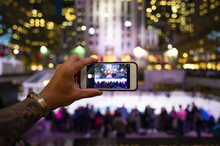 A Tourist Is Taking Pictures With His Phone At The Rockefeller Tower In New York, USA. Rockefeller Plaza Is An American Art Deco Skyscraper.