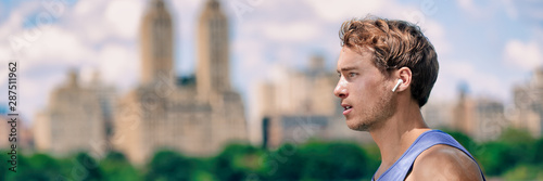 Cuadros en Lienzo Wireless earbuds man walking running in Central Park New York city listening to music with wearable technology bluetooth earphone earpods panoramic banner