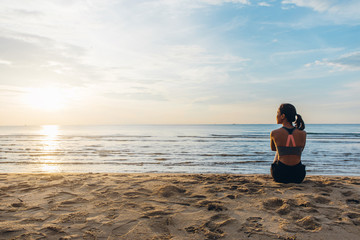 Wall Mural - Rear view of woman looking at the sea during the sunset on the beach