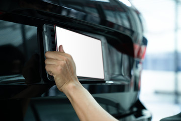 Asian man installing the licence plate of a car. Technician installing car plate. A car plate being install by Asian man. Car license plate black. licence holder adjusting on black vehicle.