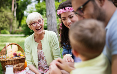 Happy family playing and enjoying picnic with children outside