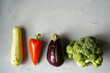 Ugly vegetables laid out in row on grey concrete background.