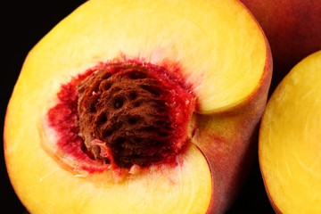 Wall Mural - Cut peach on a dark background close up