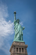 Shot of the Statue of Liberty in New York City, Usa. The shot is taken during a beautiful sunny day with a blue sky and white clouds in the background	