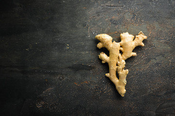 Fresh ginger root on stone background. Vitamins. Top view. Free space for your text.