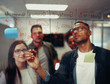 © StratfordProductions - Successful young businessmen writing on transparent glass board with red marker in office meeting