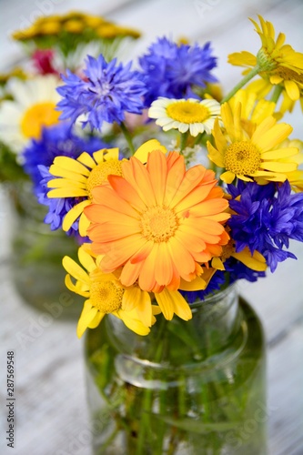 Kleiner bunter Wildblumenstrauß mit Ringelblumen und Kornblumen. Grußkarte He...