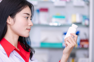 Wall Mural - asian female pharmacist in the pharmacy health care concept