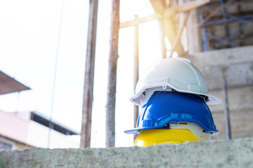 Teamwork and leadership concept, safety white, blue and yellow helmet in construction site for safe engineer and construction worker