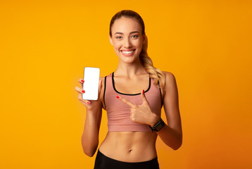Girl Pointing Finger At Cellphone Blank Screen On Yellow Background