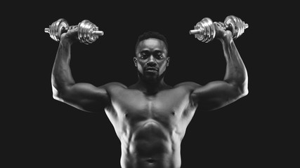 Wall Mural - African american bodybuilder pushing barbells up, working out