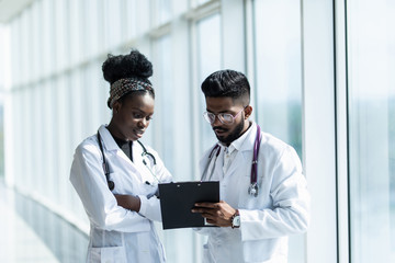 portrait of two doctors looking at a document in an office