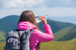 © Андрей Репетий - Female tourist with backpack drinking water in the mountains. Woman resting with water bottle during hike.