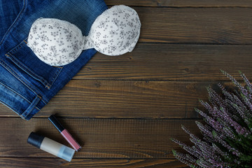 Bra, jeans and cosmetics. Flat lay. The concept of clothing, accessories, shopping, lingerie.