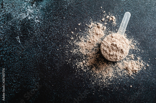 Fotomural Top view whey protein scoop on dark background, copy space