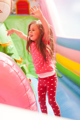 Wall Mural - A cheerful child plays in an inflatable castle