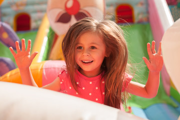 Wall Mural - A cheerful child plays in an inflatable castle