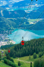 View Of St.Gilgen Village, Wolfgangsee Lake And Red Seilbahn Cable Car Gondolas From Zwolferhorn Mountain In Salzkammergut Region, Austria