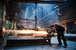 © romankosolapov - Employee grinding steel with sparks - focus on grinder. Steel factory.