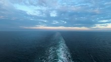 Hyper Lapse Sunset View Of The Wake From The Back Of A Ferry On A Cloudy Summer Evening