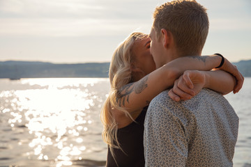 Wall Mural - Kissing couple in romantic embrace on beach at summer