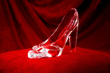 Dream And Fantasy, Classic Literature And Magical Fairy Tale Story Conceptual Idea With Clear Crystal Glass Slipper Or Shoe That Cinderella Lost In The Fairytale, On Red Pillow And Velvet Background