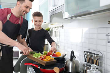 Canvas Print - Dad and son cooking together in kitchen