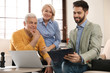 © New Africa - Male notary working with mature couple in office