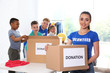© New Africa - Volunteers with children sorting donation goods indoors
