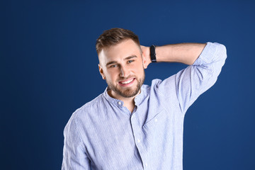 Wall Mural - Portrait of handsome happy man on color background