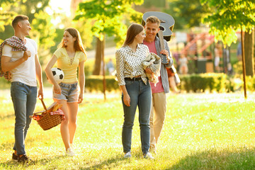 Young people with picnic basket in park on summer day