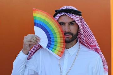 Attractive Arabic gay man holding a fan with the rainbow flag