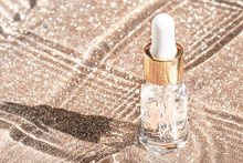 Anti Aging Serum With Collagen And Peptides In Glass Bottle With Dropper On Golden Background. Skincare Essence For Beautiful Healthy Skin. 
