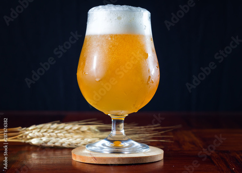 Fotografía Hazy IPA craft beer in a tulip shaped beer glass with lots of foamy head
