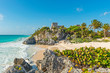 The Caribbean Sea with turquoise waters and white sand beach as a backdrop for the Tulum Maya ruins, Mexico.