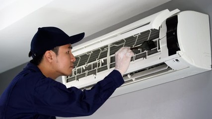 Wall Mural - technician service cleaning the air conditioner indoors