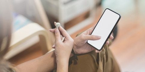 Close-up view of young female listening to the music with smartphone during the relaxing time