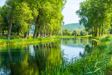Beautiful Gacka River Flowing Between Trees And Fields, Summer View, Lika Region Of Croatia