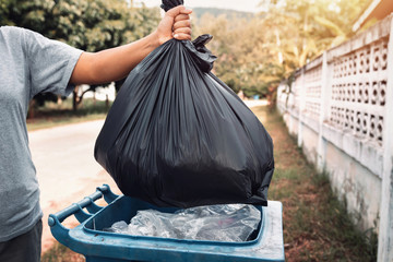 Wall Mural - woman hand holding garbage in black bag for cleaning in to trash