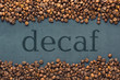 Closeup of coffee beans on grey background with the inscription decaf