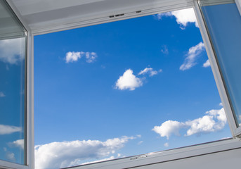 Wall Mural - an open window overlooking the urban landscape on a sunny cloud day
