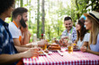 © NDABCREATIVITY - Group of happy friends eating and drinking beers at barbecue dinner