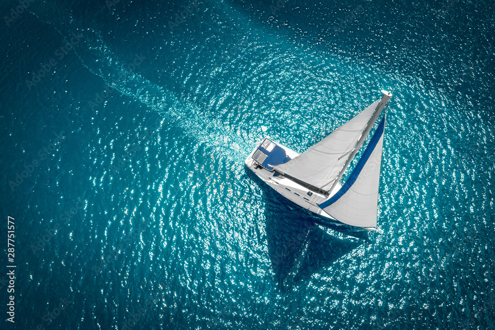 Regatta sailing ship yachts with white sails at opened sea. Aerial view of sailboat in windy condition - obrazy, fototapety, plakaty 