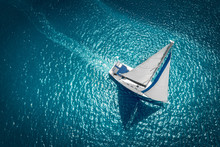 Regatta Sailing Ship Yachts With White Sails At Opened Sea. Aerial View Of Sailboat In Windy Condition