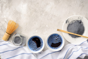 Wall Mural - Blue matcha tea in two white cup , wooden tray, bamboo tavan and tasaku, powder on white background