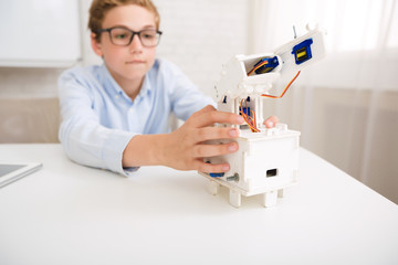 Poster - Smart schoolboy constructing electronic robot in class