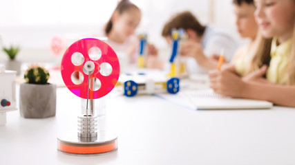 Poster - Handmade robotic wheel on desk with schoolchildren on background
