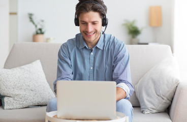 Poster - Man In Earphones Using Laptop Listening To Podcast At Home