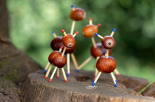 Group Of Funny Chestnut Animals On Tree Stump, Green Background, Traditional Autumn Handcraft, European Roe Deer With Family